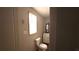 A bright bathroom features a toilet, a vanity with a mirror, and a window offering natural light at 3915 Dahlonega Hwy, Cumming, GA 30028