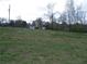 View of a large grassy lot with a cozy home and storage shed, offering ample space and potential at 3915 Dahlonega Hwy, Cumming, GA 30028