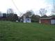 Spacious lawn with single-story home, storage shed, parking, and a tree-lined backdrop at 3915 Dahlonega Hwy, Cumming, GA 30028