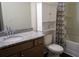 This bathroom features a granite countertop, toilet, storage cabinet, and a shower with a leaf-patterned curtain at 5317 Radford Loop, Fairburn, GA 30213