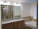 Elegant bathroom featuring granite countertops, double vanity, soaking tub, and tiled shower with glass door at 5317 Radford Loop, Fairburn, GA 30213