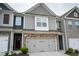 Charming townhome featuring stone accents and a two-car garage for convenience and curb appeal at 5317 Radford Loop, Fairburn, GA 30213