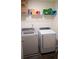 The laundry room features new white front load washer and dryer units, with storage shelf above at 5317 Radford Loop, Fairburn, GA 30213