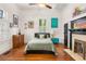 Bright bedroom featuring hardwood floors, high ceilings, a ceiling fan, and a decorative fireplace at 290 Georgia Se Ave, Atlanta, GA 30312