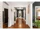 Long hallway featuring hardwood floors, white wainscoting, dark doors, and unique decor at 290 Georgia Se Ave, Atlanta, GA 30312
