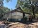 A view of the front exterior showing boarded up windows and overgrown landscaping of a single-story home at 3008 Grand Sw Ave, Atlanta, GA 30315