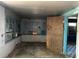 A view of the living room needing repairs including bare walls and damaged flooring with plywood at 3008 Grand Sw Ave, Atlanta, GA 30315