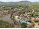 Aerial view of a neighborhood featuring a community pool, tennis courts, and homes near a lake and lush trees at 3275 Aldrich Dr, Cumming, GA 30040