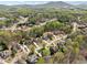 Aerial view of homes in a lush green, wooded neighborhood, with scenic mountains in the distance at 3275 Aldrich Dr, Cumming, GA 30040