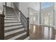Elegant foyer with hardwood floors, a staircase with iron railings, and a large window providing natural light at 3275 Aldrich Dr, Cumming, GA 30040