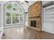 Living room with stone fireplace and a large arched window offering a view of the greenery outside at 3275 Aldrich Dr, Cumming, GA 30040