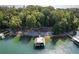 Aerial view of a dock with boat slip, surrounded by trees and lake, creating a private retreat at 6160 Lake Lanier Heights Rd, Buford, GA 30518