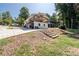 A spacious backyard featuring a covered deck, a set of stairs, and lush greenery at 6160 Lake Lanier Heights Rd, Buford, GA 30518