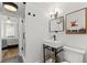Modern bathroom with a white sink, black fixtures, and a unique art print above the toilet at 6160 Lake Lanier Heights Rd, Buford, GA 30518