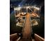 Illuminated boat dock featuring a covered boat slip, a jet ski lift, and a staircase leading to an upper deck at 6160 Lake Lanier Heights Rd, Buford, GA 30518