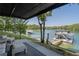 Covered patio with lake views and seating area, with a boat dock visible at 6160 Lake Lanier Heights Rd, Buford, GA 30518