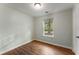 This bedroom has light-colored walls, wood-look floors, and a sunny window at 700 Thomasville Se Blvd, Atlanta, GA 30315