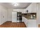 Well-lit kitchen with white cabinets, laminate floors, and stainless steel oven at 700 Thomasville Se Blvd, Atlanta, GA 30315