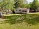 Home exterior with manicured lawn, mature trees, and a welcoming front porch at 1643 Cumberland Trce, Acworth, GA 30102