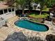 Backyard pool and patio with wooden decking, stone accents, and lush landscaping at 1643 Cumberland Trce, Acworth, GA 30102