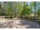 Outdoor deck with wooden floorboards and white railing offers tranquil views of the surrounding lush, wooded landscape at 2050 Heritage Green Dr, Marietta, GA 30064