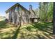 Back of the home featuring a spacious yard and an elevated wooden deck, nestled among mature trees and lush greenery at 2050 Heritage Green Dr, Marietta, GA 30064