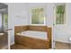 Bathroom featuring a soaking tub, tile surround, and natural light at 2050 Heritage Green Dr, Marietta, GA 30064