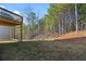 Backyard has a gentle slope with tree coverage and a peek at a deck at 3205 Tackett Rd, Douglasville, GA 30135
