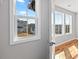 Light-filled bedroom with hardwood floors and a view of a neighboring home through three large windows at 3205 Tackett Rd, Douglasville, GA 30135