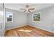 Sunlit bedroom with hardwood floors, ceiling fan, and well-placed windows offering pleasant views and natural light at 3205 Tackett Rd, Douglasville, GA 30135