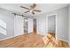 Modern bedroom with hardwood floors, ceiling fan, barn door to bathroom, and a closet; ample natural light at 3205 Tackett Rd, Douglasville, GA 30135