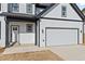 Close up view of a white two-story new construction home, showing the garage and entry door at 3205 Tackett Rd, Douglasville, GA 30135