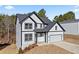 Two-story home featuring white siding, black trim, well-manicured lawn, and an attached garage at 3205 Tackett Rd, Douglasville, GA 30135
