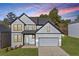 Charming two-story home featuring gray siding, black trim, and a well-manicured lawn at sunset at 3205 Tackett Rd, Douglasville, GA 30135