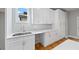 Bright kitchen features modern white cabinetry and countertops, stainless steel sink, and hardwood flooring at 3205 Tackett Rd, Douglasville, GA 30135