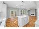 Modern kitchen features white cabinets, hardwood floors, an island and a fireplace at 3205 Tackett Rd, Douglasville, GA 30135