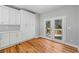 Kitchen featuring modern white cabinetry and countertop, stainless steel sink, hardwood flooring, and deck access at 3205 Tackett Rd, Douglasville, GA 30135
