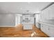 Bright kitchen features a kitchen island, modern light fixtures, and gorgeous hardwood floors at 3205 Tackett Rd, Douglasville, GA 30135