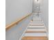 Bright staircase features wood treads, white risers, and a wood handrail leading to an upper level with black iron railings at 3205 Tackett Rd, Douglasville, GA 30135