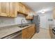 Galley-style kitchen with stainless steel appliances, granite counters, and light wood cabinets at 4430 Tilly Mill Rd # 1304, Atlanta, GA 30360