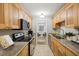 Galley kitchen featuring wooden cabinetry, granite countertops, and stainless steel appliances at 4430 Tilly Mill Rd # 1304, Atlanta, GA 30360