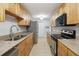 Galley-style kitchen with stainless steel appliances, granite counters, and light wood cabinets at 4430 Tilly Mill Rd # 1304, Atlanta, GA 30360