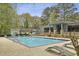 Community pool and outdoor lounge chairs with lush trees at 4430 Tilly Mill Rd # 1304, Atlanta, GA 30360