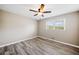 This bedroom boasts a ceiling fan, wood-look floors, and natural light with its large window at 294 Arnold Mill Rd, Woodstock, GA 30188