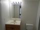 Bathroom featuring a vanity with wooden cabinets, a sink, large mirror, and a toilet at 3091 Colonial Way # B4, Atlanta, GA 30341