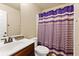 Cozy bathroom featuring a combination shower and tub with a purple and white shower curtain at 3169 Shadystone Way, Loganville, GA 30052