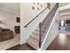 Elegant staircase with decorative iron railings, carpeted steps, and hardwood flooring at 3169 Shadystone Way, Loganville, GA 30052