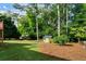 Expansive backyard featuring lush green grass, mature trees, and two storage sheds providing ample outdoor space at 3925 Orchard Se Rd, Smyrna, GA 30080