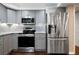 This kitchen has stainless steel appliances and gray cabinets at 3925 Orchard Se Rd, Smyrna, GA 30080
