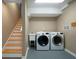 This laundry room has a laundry tub, stairs and modern washer and dryer at 3925 Orchard Se Rd, Smyrna, GA 30080